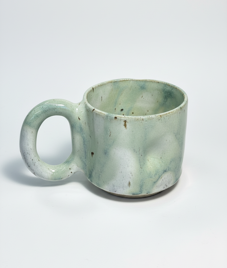 Green marbled handmade ceramic mug on a white background